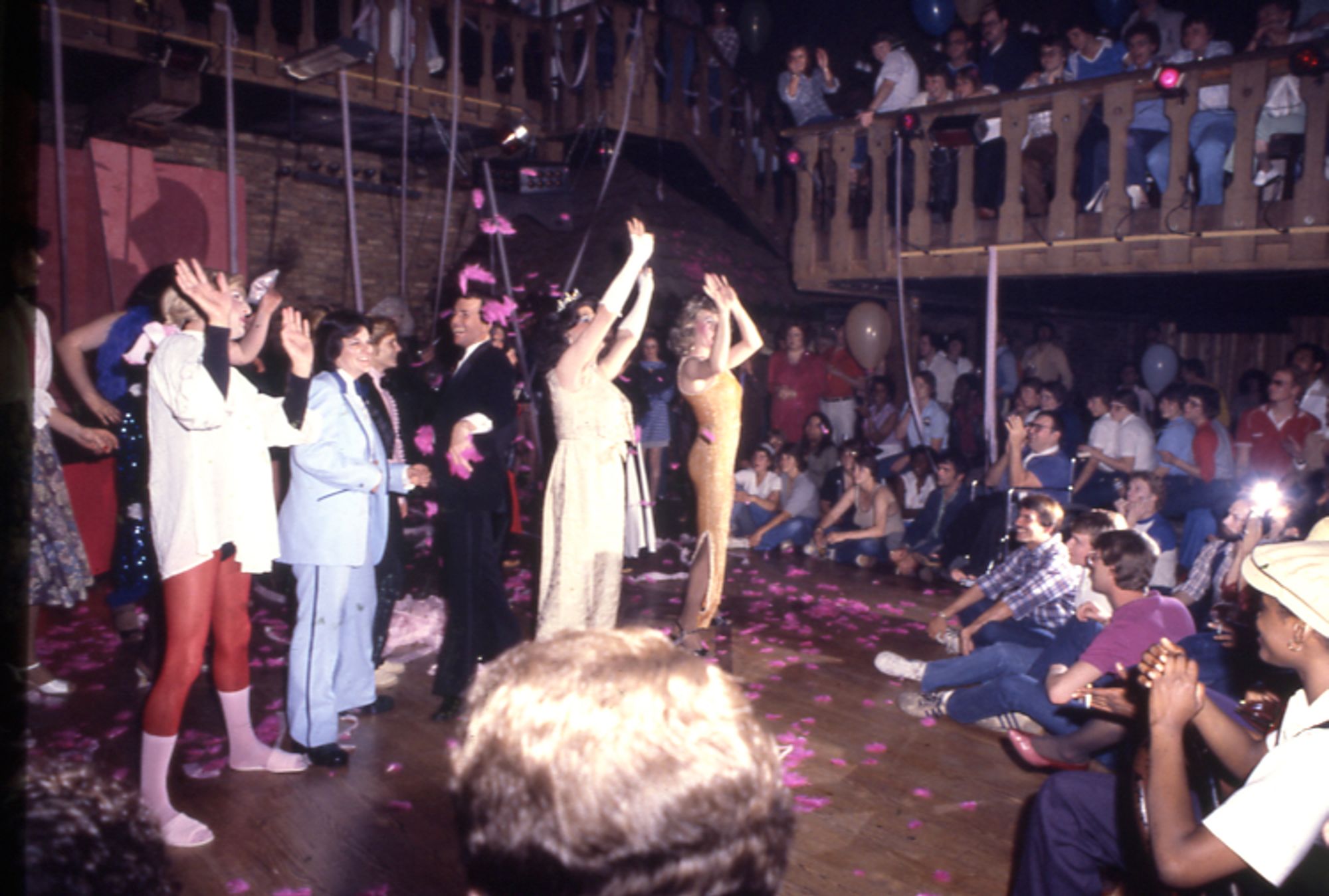 Drag performance at the bar. Performers stand in front of a cheering crowd.