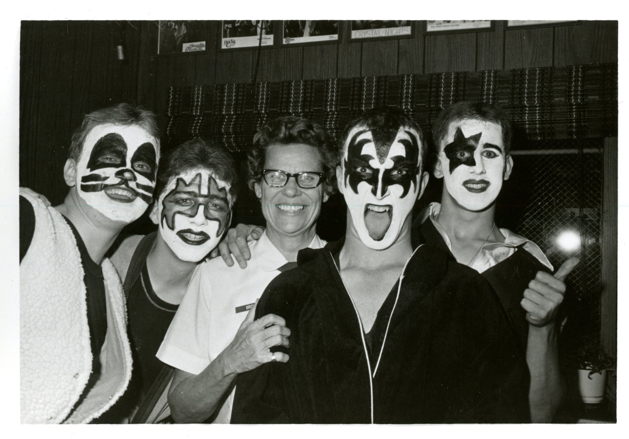 Major General Norma E. Brown posing and smiling with Chanuters dressed as the band Kiss.