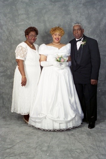 A 1996 Cotillion member poses with her parents on either side.