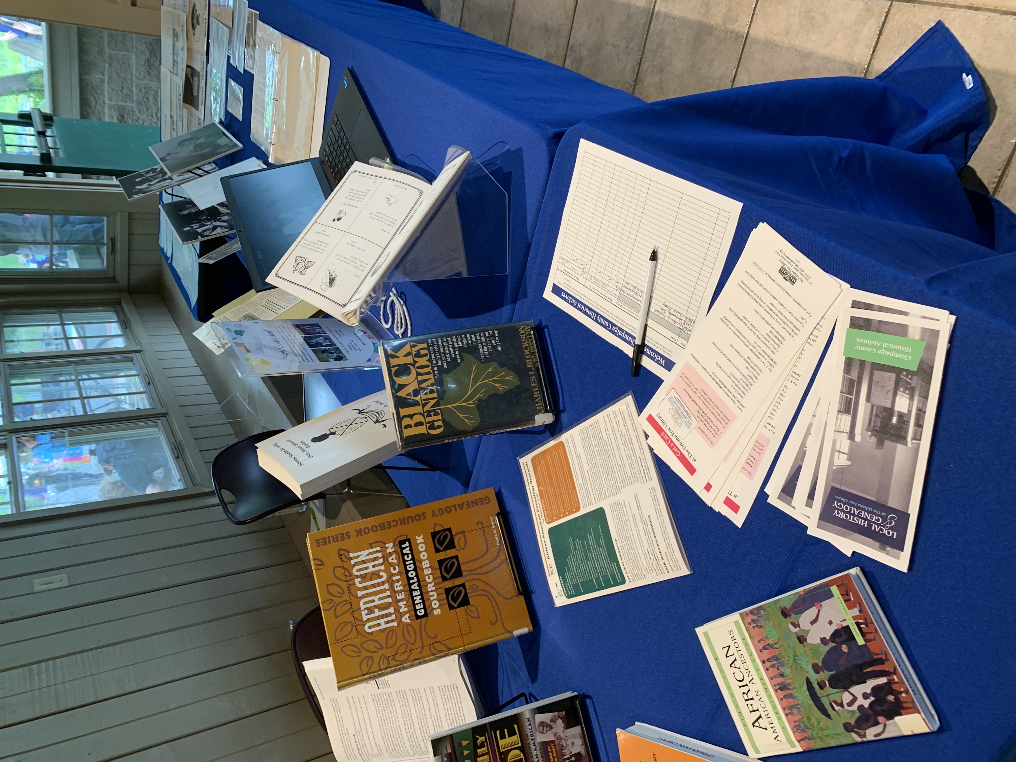 Books, brochures, and archival material displayed on a table with a blue tablecloth.