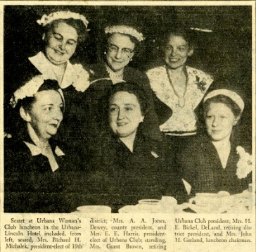 An image of a newspaper clipping of a group of six women, members of the Urbana Woman's Club, at the 1955 Spring Luncheon. The caption below reads, "Sextet at Urbana Woman's Club luncheon in the Urbana-Lincoln Hotel included, from left, seated, Mrs. Richard H. Michalek, president-elect of 19th district; Mrs. A. A. Jones, Dewey, county president, and Mrs. E. E. Harris, president elect of Urbana Club; standing, Mrs. Grant Brown, retiring Urbana Club president; Mrs. H. E. Bickel, DeLand, retiring district president, and Mrs. John H. Garland, luncheon chairman. 