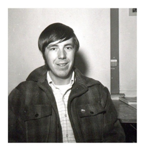 Black and white photograph of Phil Greer from the chest up. He is facing the camera and smiling. Greer was a staff photographer for the Courier newspaper.