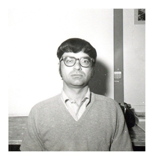 Black and white photograph of Jim Rutledge from the chest up. He is wearing glasses and looking straight at the camera, unsmiling. Rutledge was a staff photographer for the Courier newspaper.