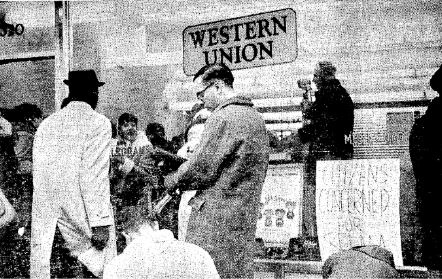 Protestors fill out telegrams to President Johnson outside of the Western Union office