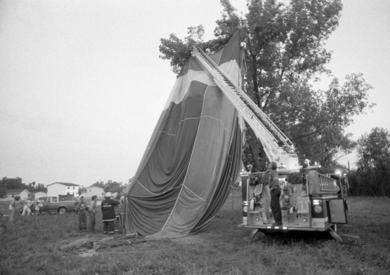 Deflated hot air balloon being untangled from a tree by the fire department