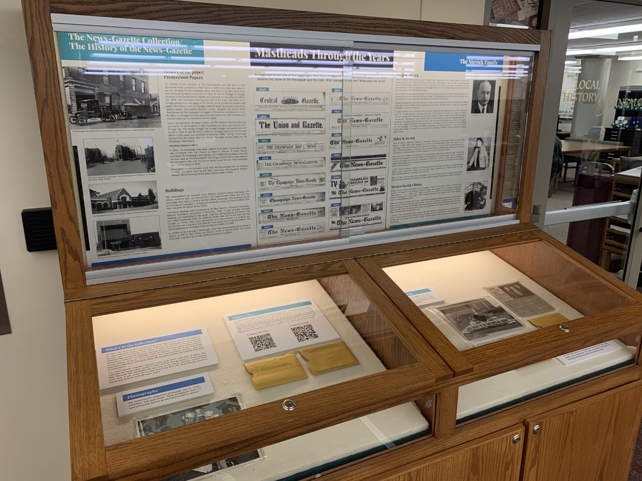 Photograph of the exhibit case outside of the Archives. The case contains an exhibit about the history of The News-Gazette and The News-Gazette Collection