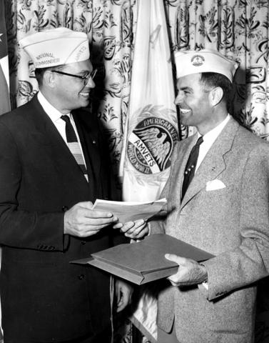 MARSHALL E. MILLER, MEMBER OF CHAMPAIGN POST THREE OF THE AMERICAN VETERANS OF WORLD WAR II, RECEIVING PAPERS FROM AMVETS EXECUTIVE DIRECTOR DAVID SCHLOTHAUER