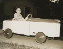 Boy in soap box derby car