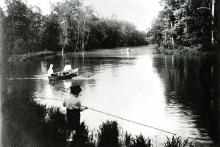 Boy by Crystal Lake with canoe, 1910
