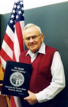 Donald O. Weckhorst holding copy of Chanute’s 75-Year Pictorial History, 2000