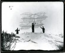Chaute Glider, glider prototype with 3 men standing at to of a sand dune